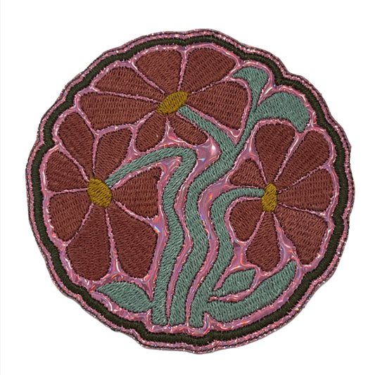 Handmade floral iron-on patch featuring muted pink flowers, teal green stems, and dark pink outline.