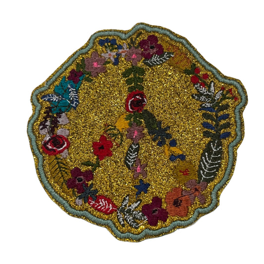 Handmade floral peace sign iron-on patch with gold glitter background and multicolor embroidery.