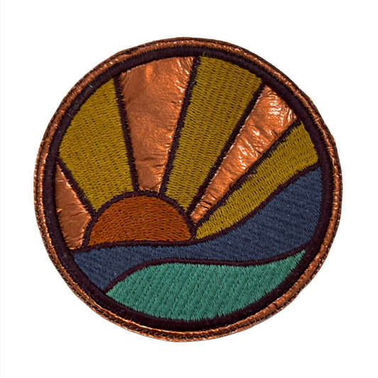 Retro sunset iron-on patch with vibrant vintage flair, featuring colorful orange, yellow, blue, and green design.