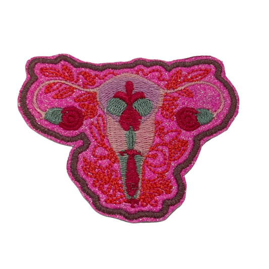 Handmade uterus iron-on patch with neon pink floral empowerment design.