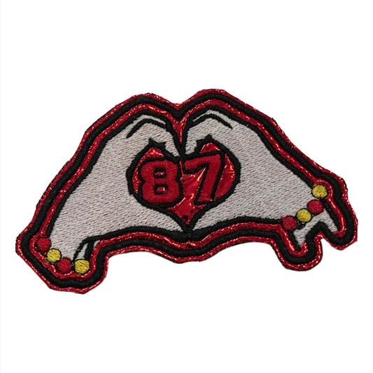 Taylor Swift heart hands iron-on patch with number 87, celebrating Travis Kelce.