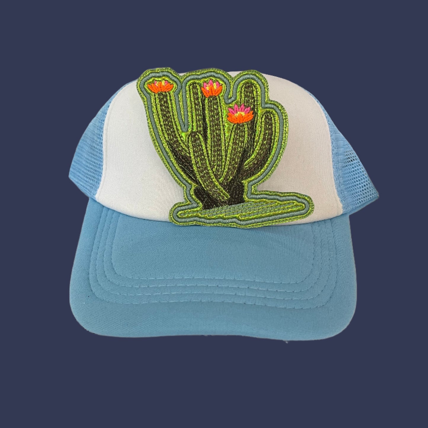 Iron-on patch featuring a large leggy cactus with neon pink, neon yellow, and neon orange flowers, green metallic vinyl showing through stitching gaps, and an aqua outline.