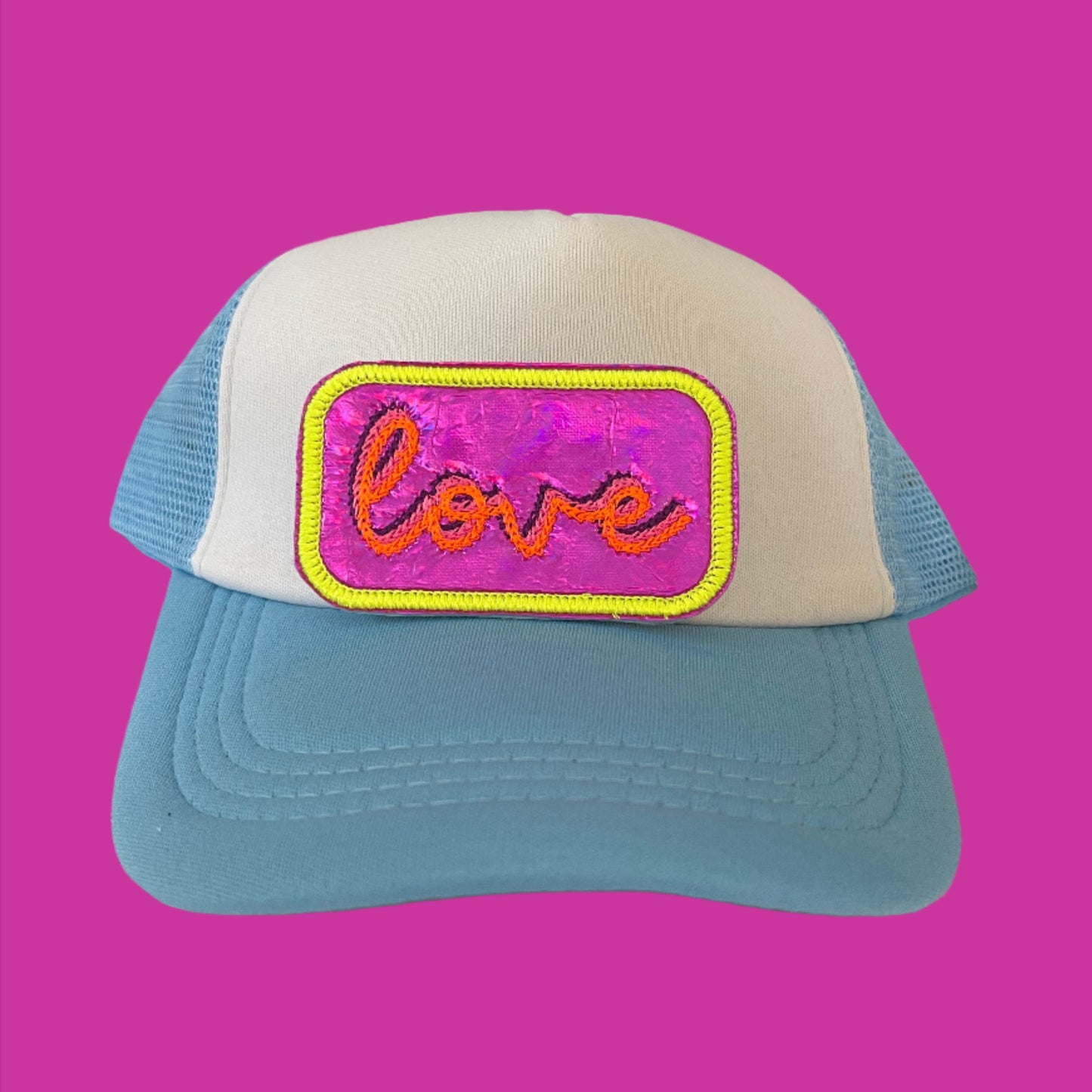 Neon iron-on patch featuring the word "love" in vibrant colors, set against a shiny, eye-catching background, showcasing a bold and retro aesthetic.