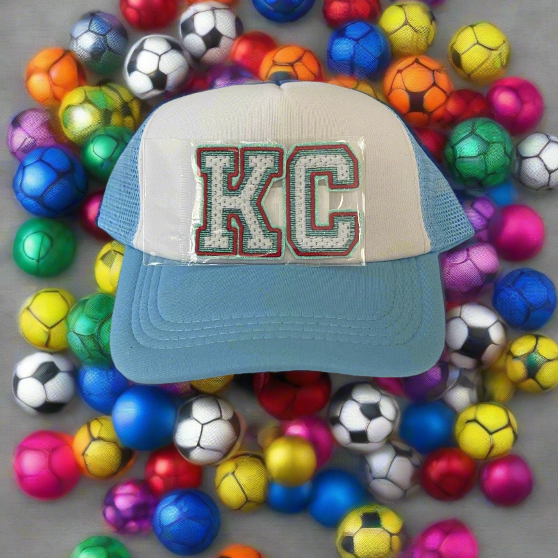 Iron-on patch featuring bold "KC" letters in Kansas City Current team colors, showcasing a stylish and vibrant aesthetic.