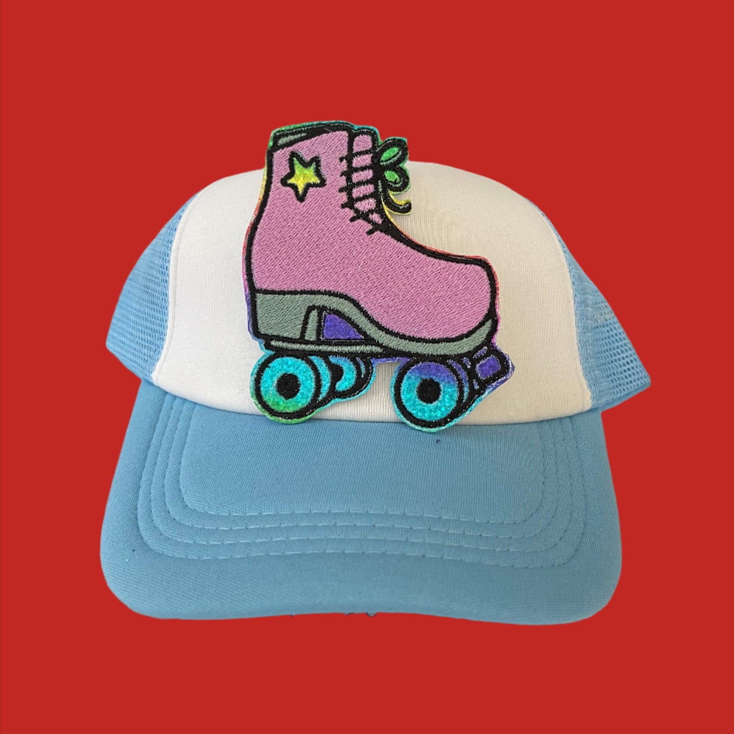 Handmade iron-on patch featuring a retro lavender roller skate with teal wheels and a star detail, perfect for adding to clothing, bags, or hats.