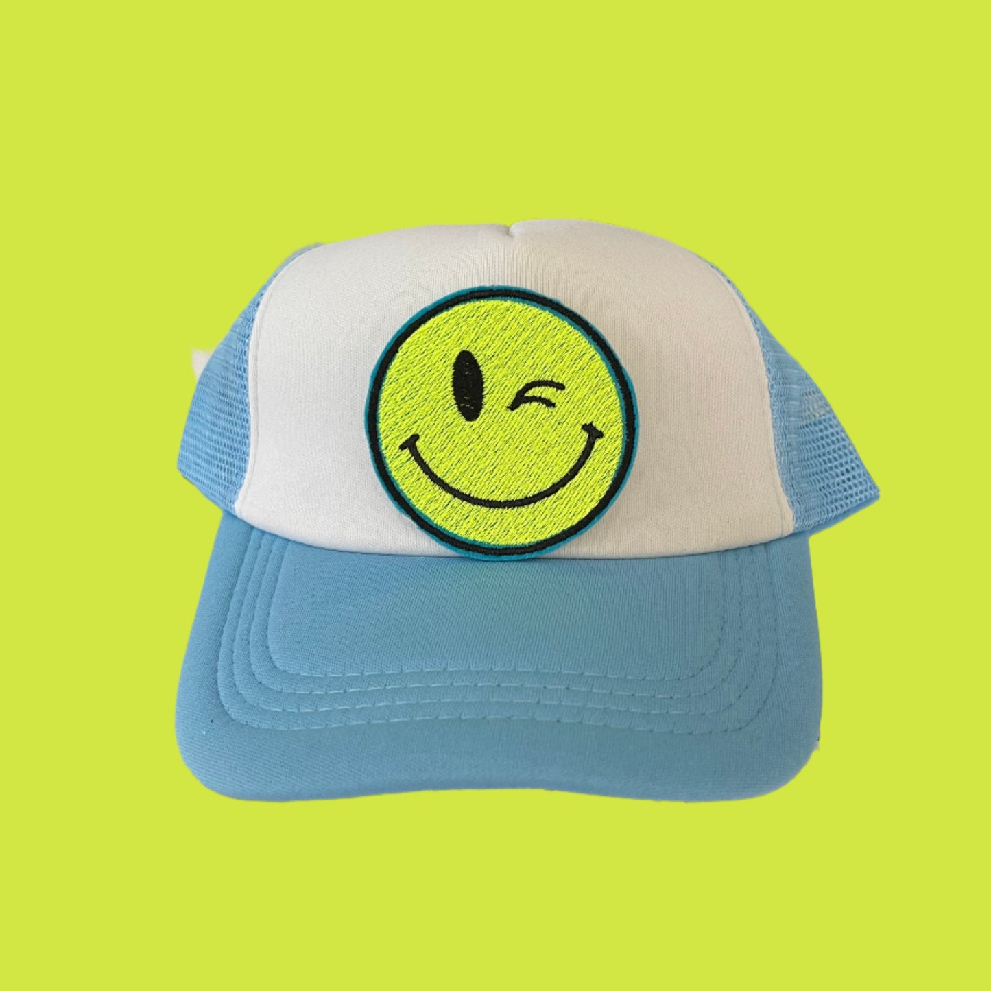 Iron-on patch featuring a bright yellow winking smiley face, showcasing a playful and retro aesthetic.
