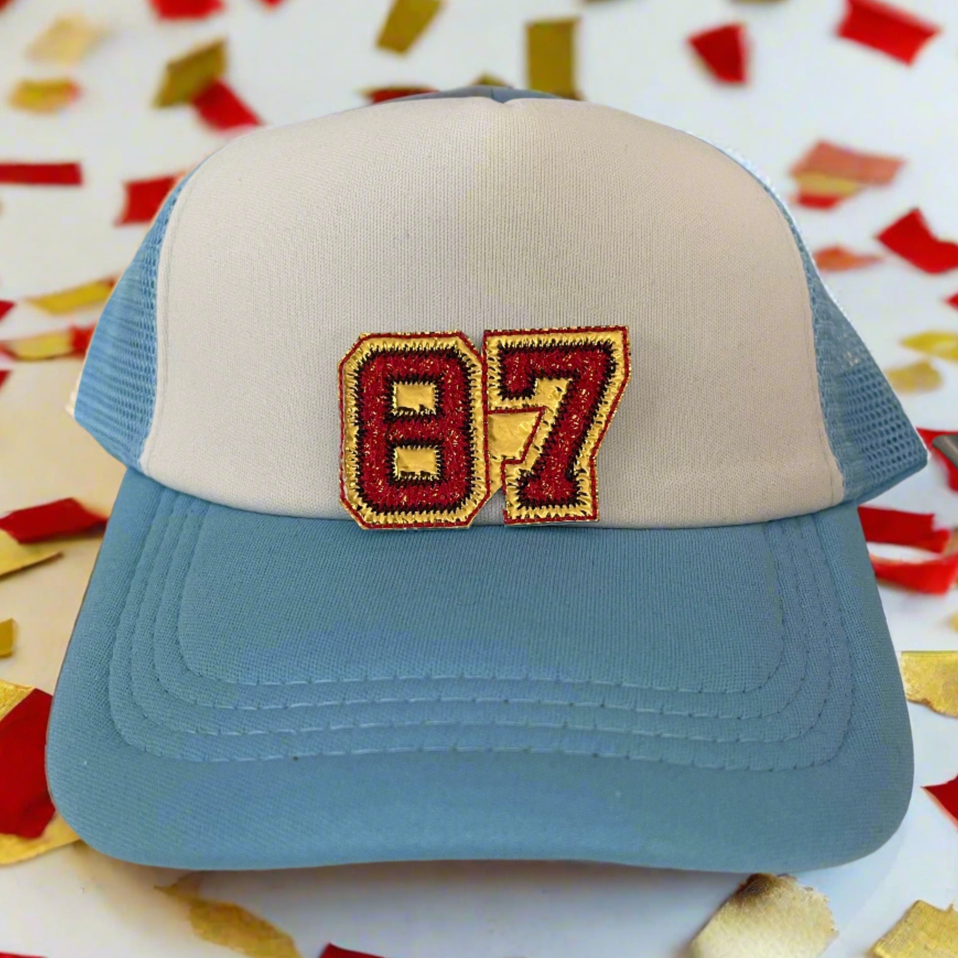Close-up of a Travis Kelce 87 embroidered patch in red and yellow, perfect for customizing hats and other accessories.