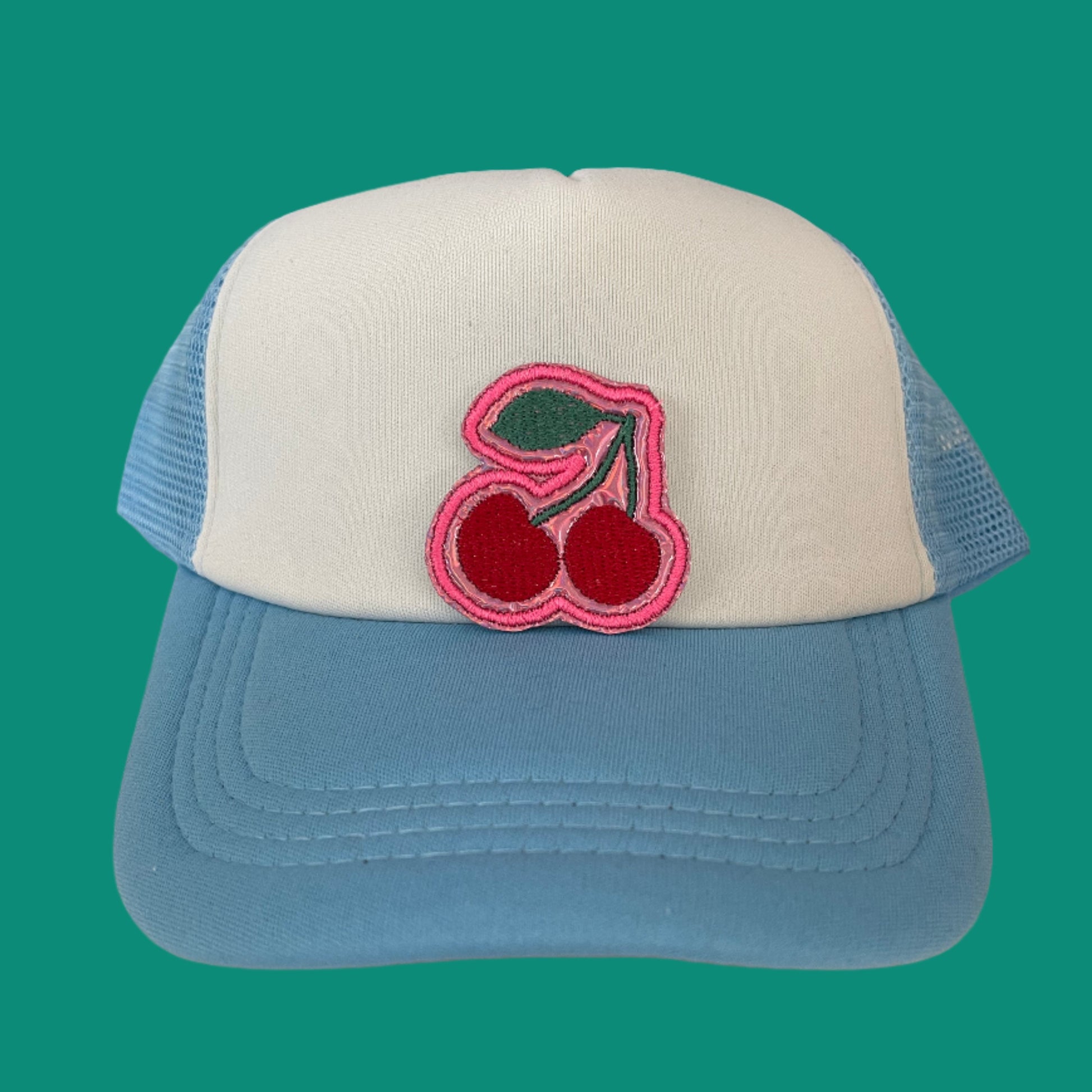 Close-up of a cherry embroidered patch with red and pink detailing, perfect for customizing hats and other accessories.