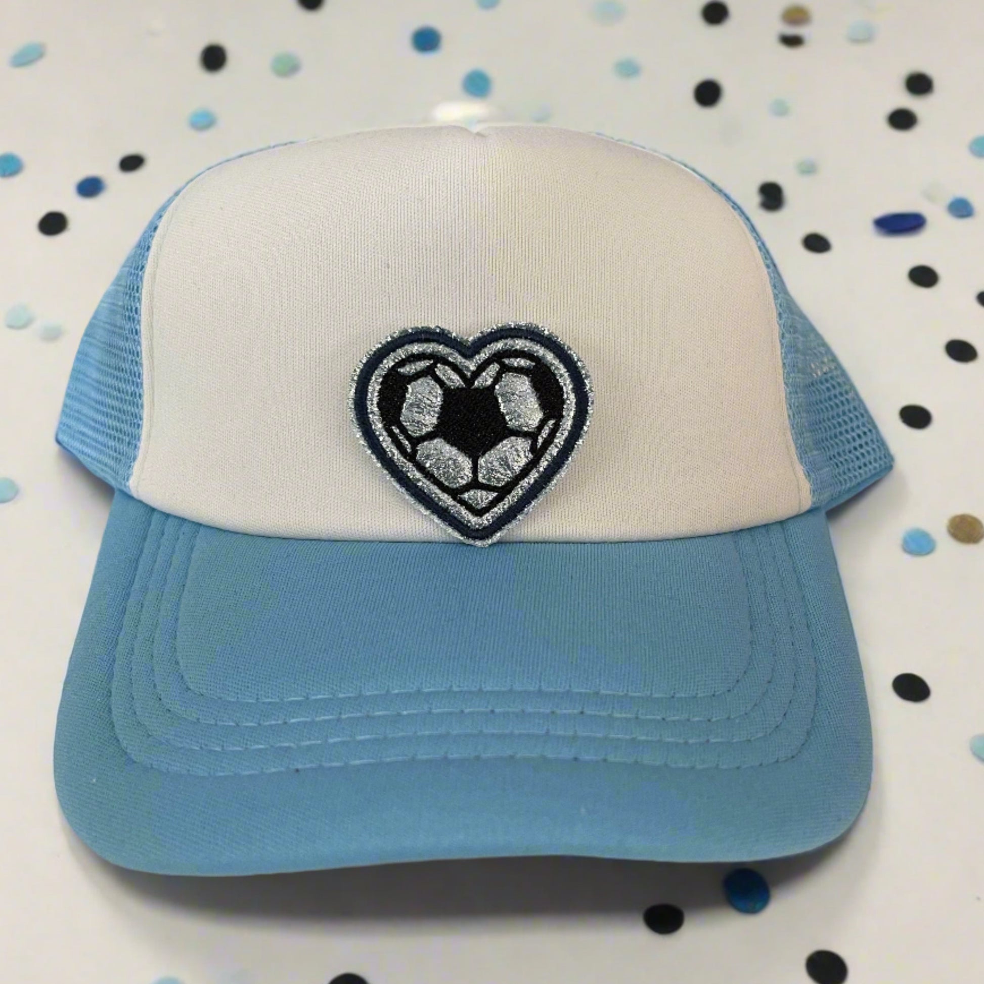Close-up of a soccer heart embroidered patch in Sporting Kansas City team colors, perfect for customizing hats and other accessories.