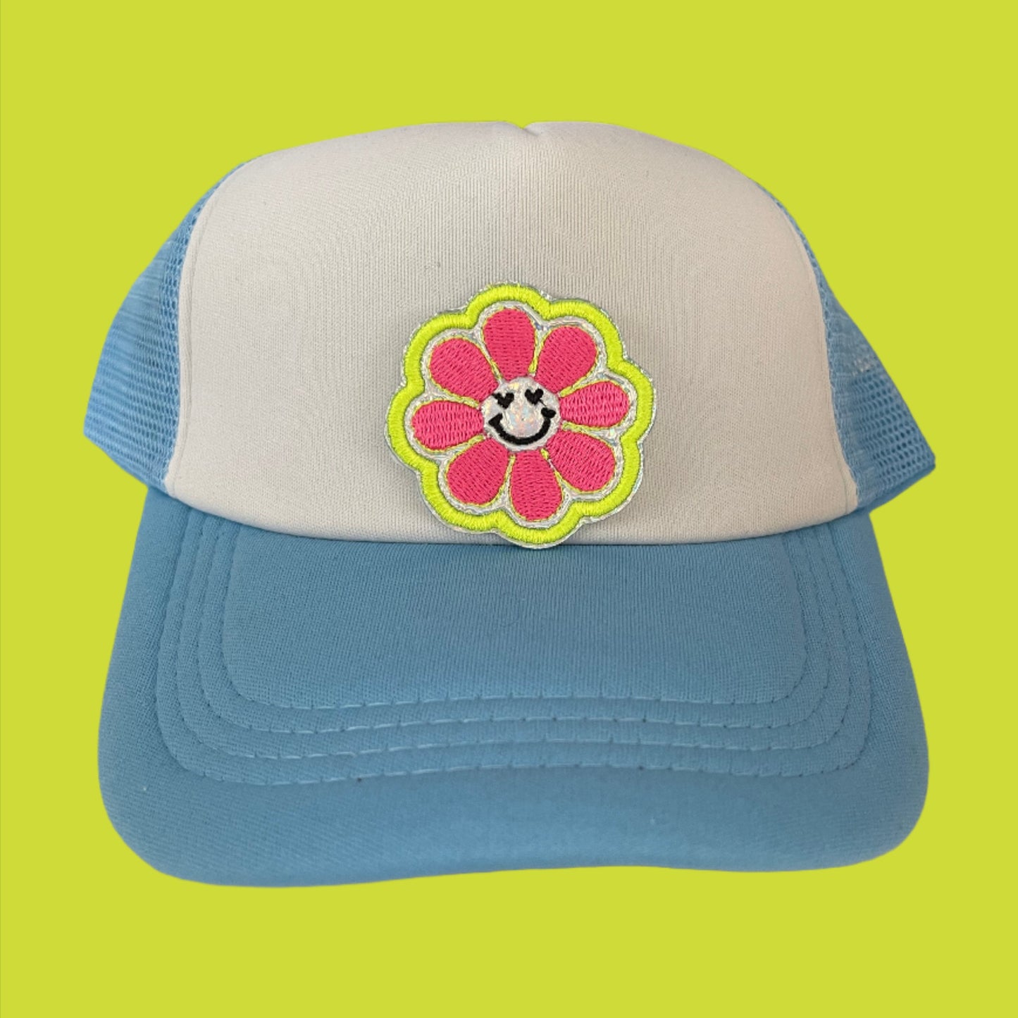 Close-up of a smiley flower embroidered patch with pink petals and a happy face, perfect for customizing hats and other accessories.