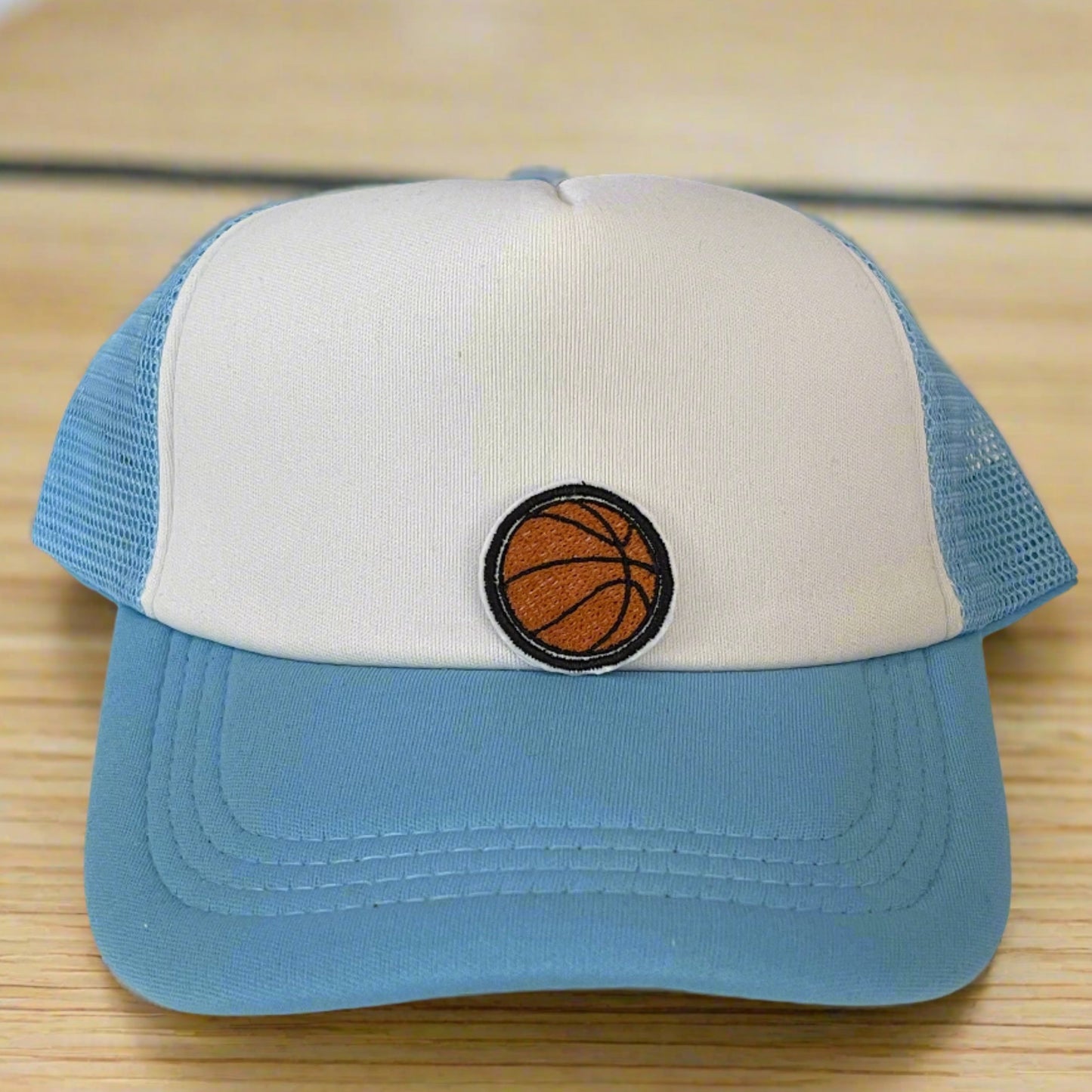 Close-up of a basketball embroidered patch with orange and black detailing, perfect for customizing hats and other accessories.