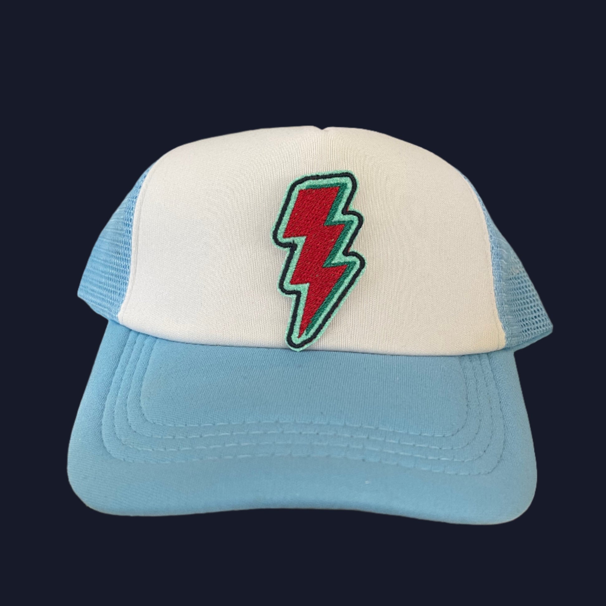 Close-up of a vibrant lightning bolt patch in Kansas City Current team colors on a hat.