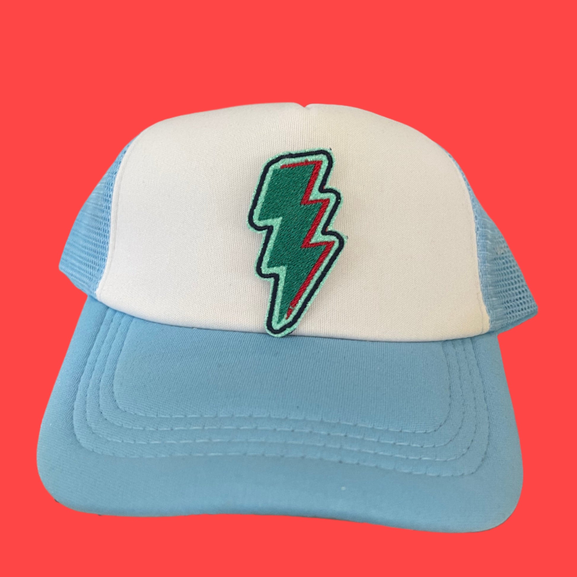 Close-up of a vibrant lightning bolt patch in Kansas City Current team colors on a hat.