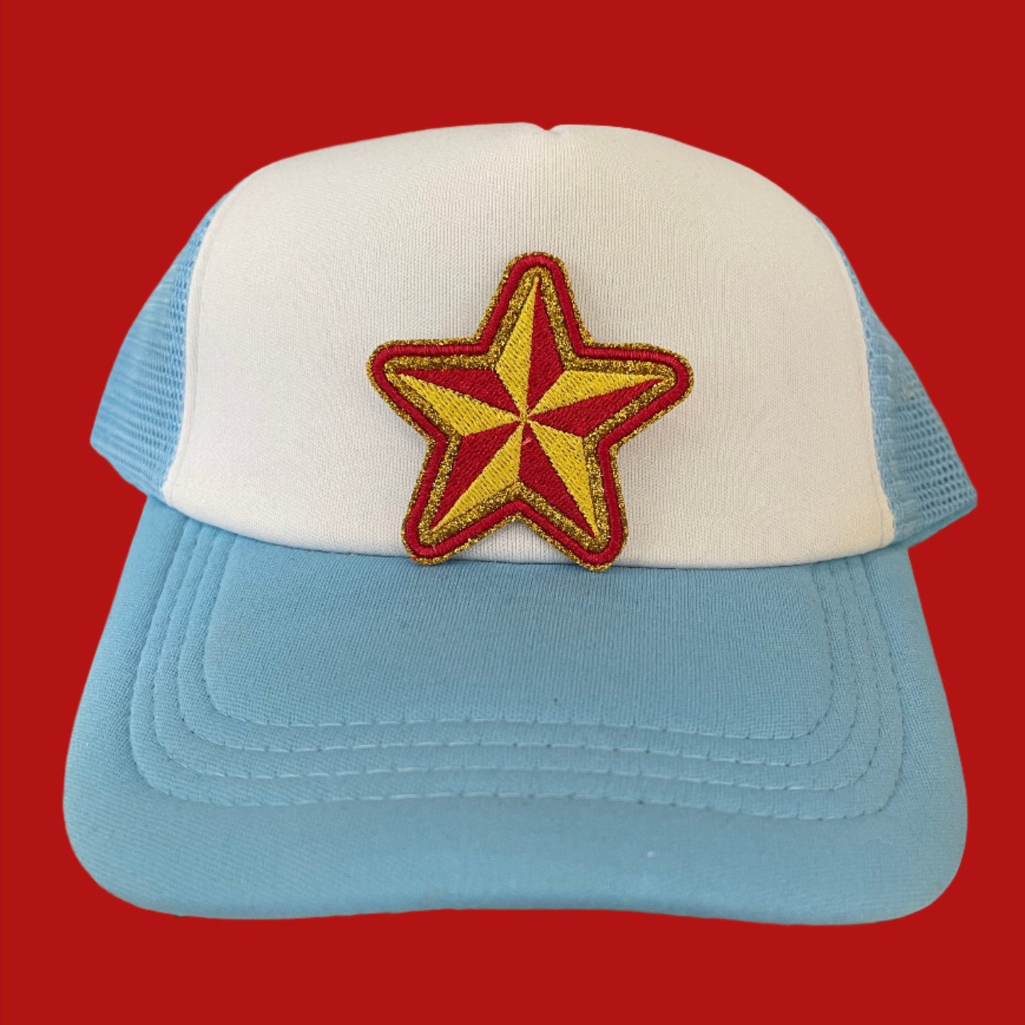 Close-up of a bold red and yellow star embroidered patch on a hat.