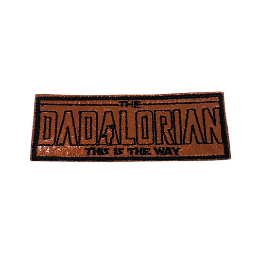 Handmade Dadalorian patch with bold lettering and a Mandalorian-inspired design in copper and black.