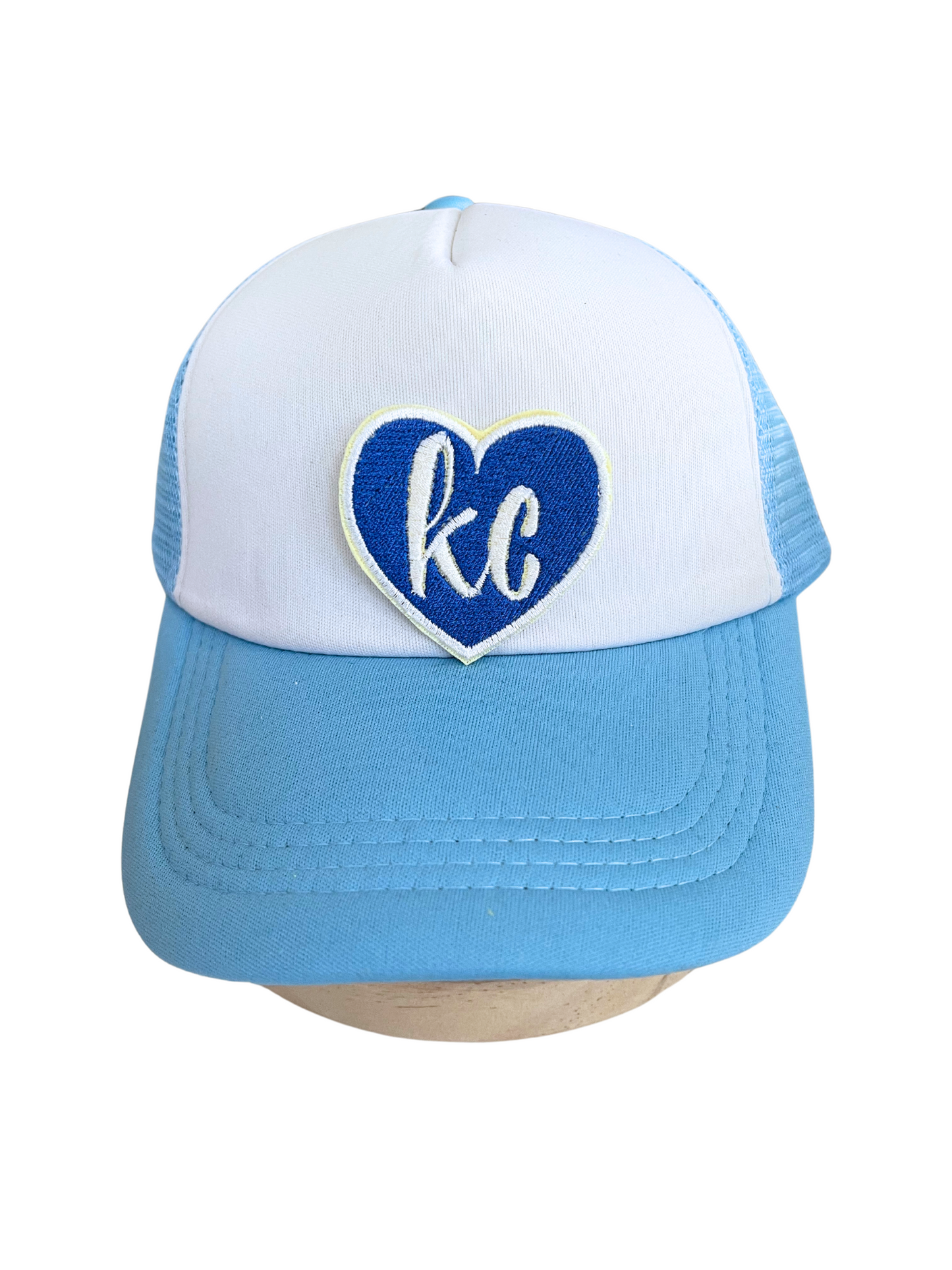 "Blue heart patch with 'KC' letters in white embroidery"