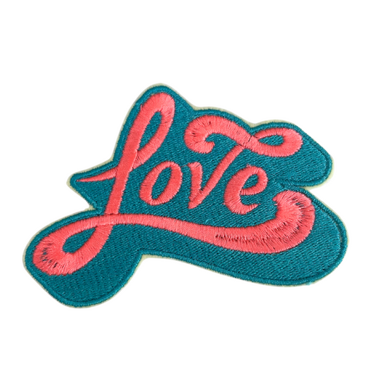 Close-up of embroidered "Love" patch in teal and pink colors.