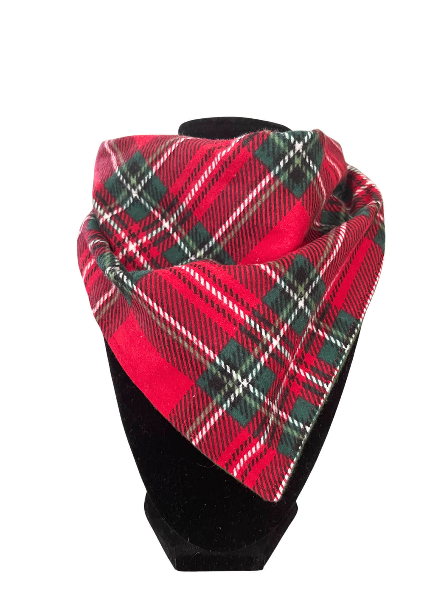 Reversible holiday plaid bib-dana with red, green, and white plaid pattern and solid red cotton flannel on the reverse, featuring adjustable snap closures, displayed on a black mannequin.