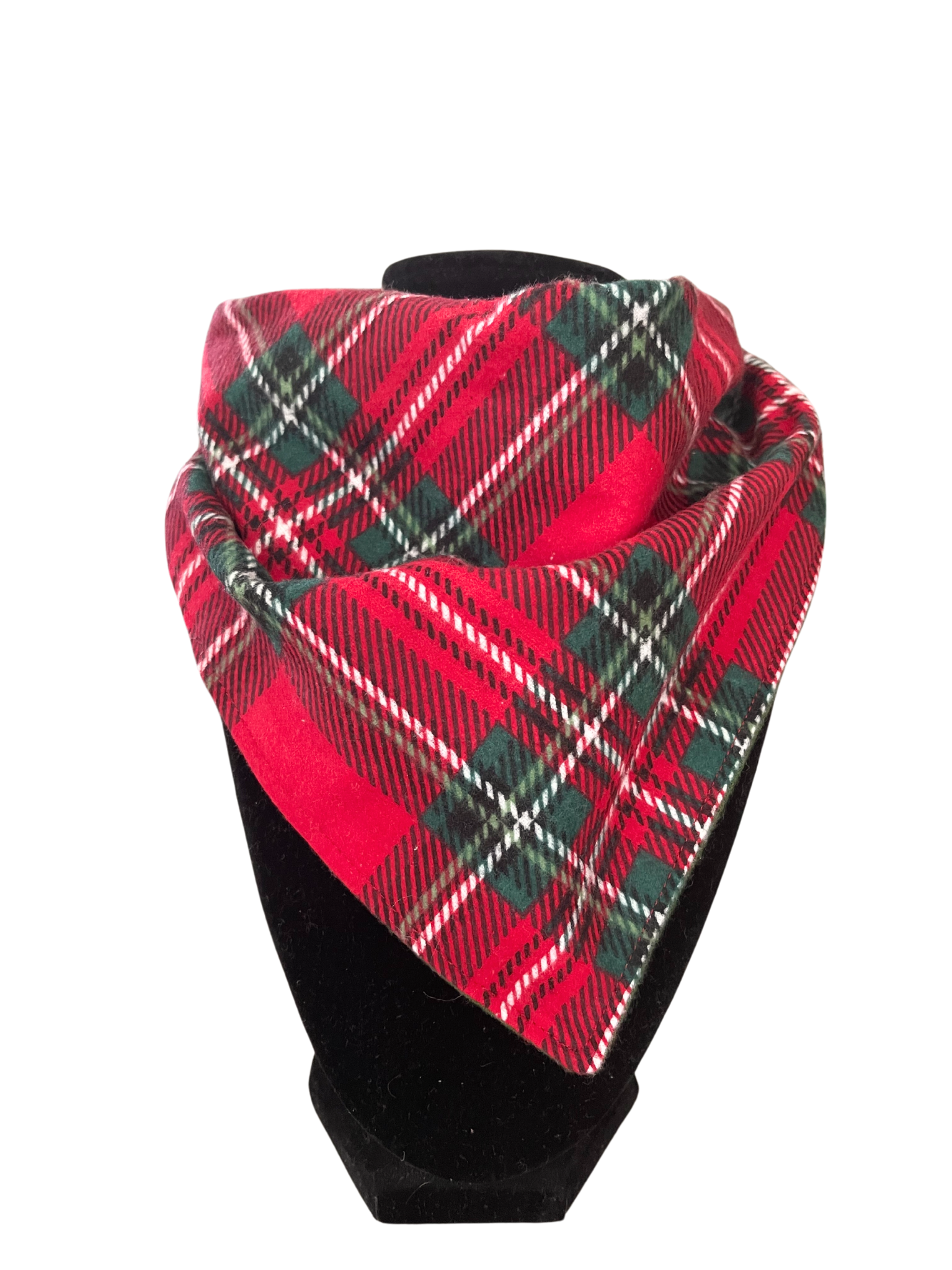 Reversible holiday plaid bib-dana with red, green, and white plaid pattern and solid red cotton flannel on the reverse, featuring adjustable snap closures, displayed on a black mannequin.