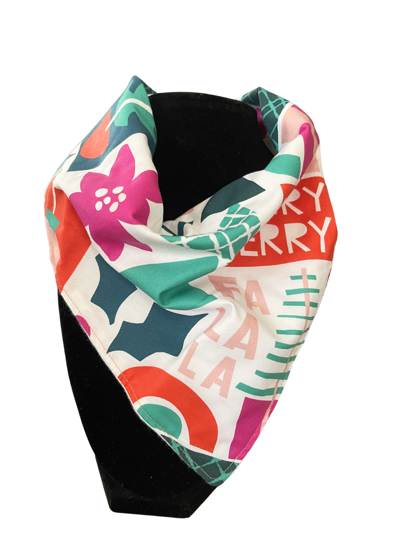 Festive reversible bib-dana with holiday-themed pattern and solid color cotton flannel on the reverse, featuring adjustable snap closures, displayed on a black mannequin.