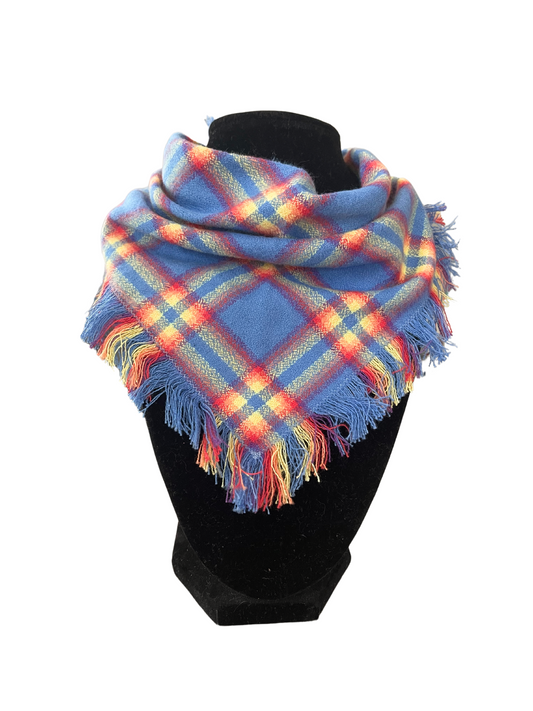 Colorful plaid fringe bib-dana scarf with blue, red, yellow, and green colors, featuring adjustable snap closures, displayed on a black mannequin.