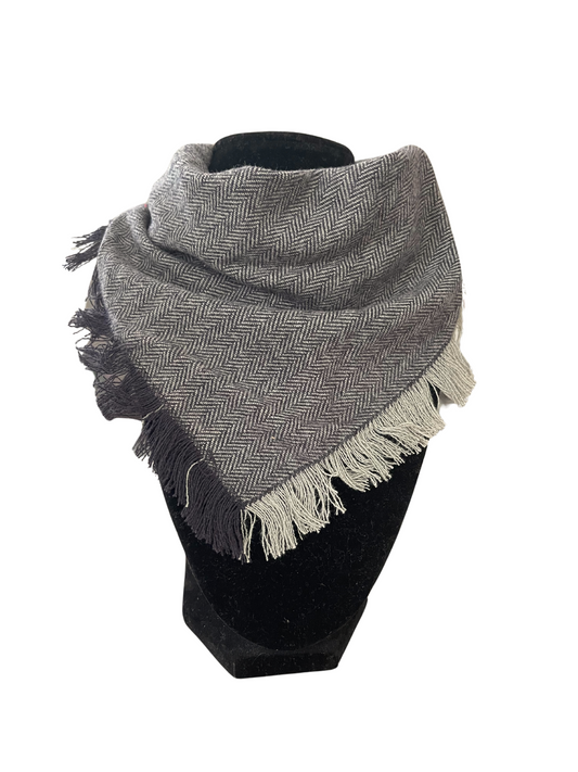 Black and gray herringbone fringe bib-dana scarf with adjustable snap closures displayed on a black mannequin.