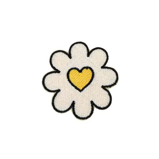 Handmade daisy patch with a yellow heart center, embroidered on fabric.