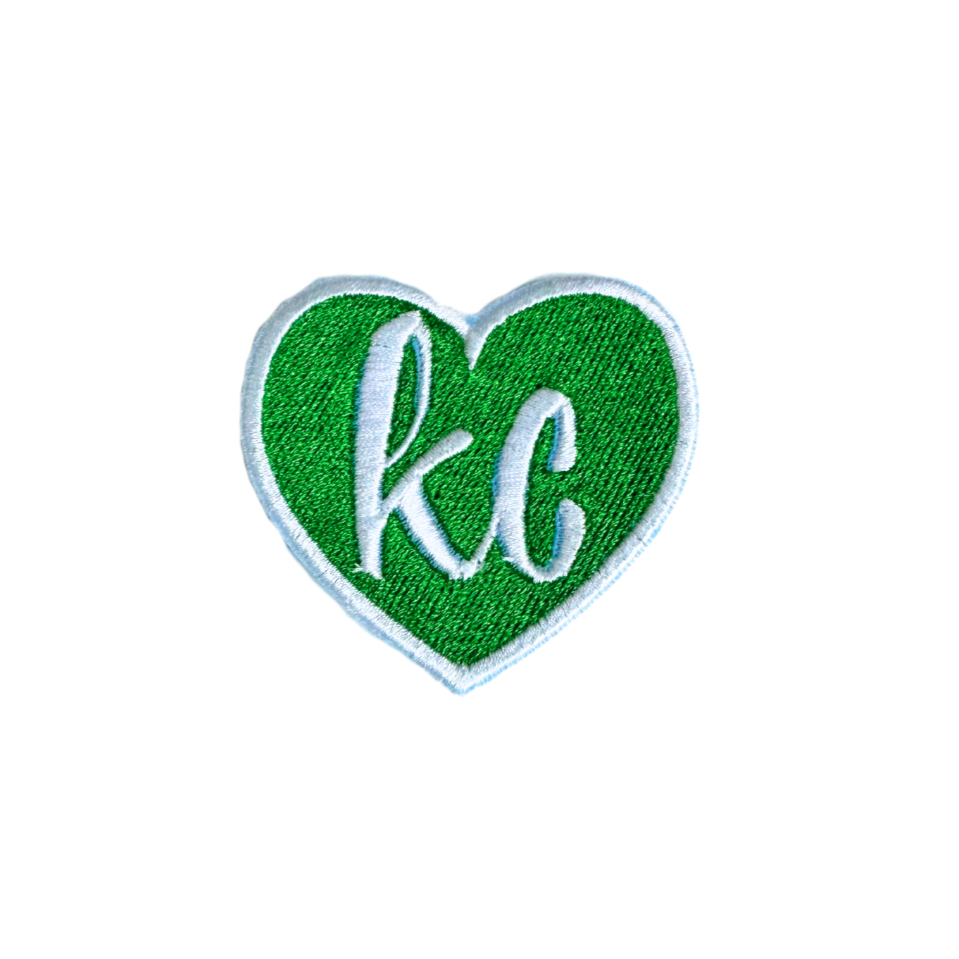 Green heart patch with white "KC" lettering.

