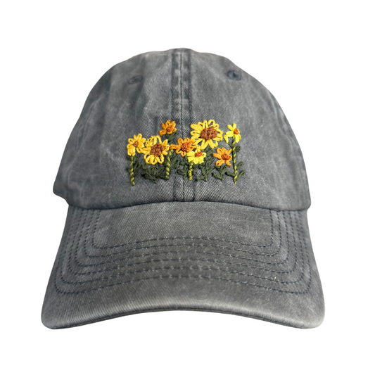 Hand-embroidered sunflower design on grey baseball cap.

