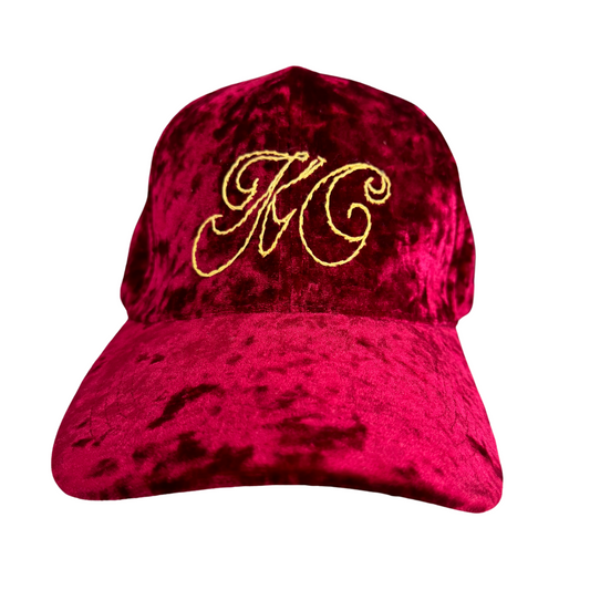 Hand-embroidered gold script KC logo on burgundy velvet hat.

