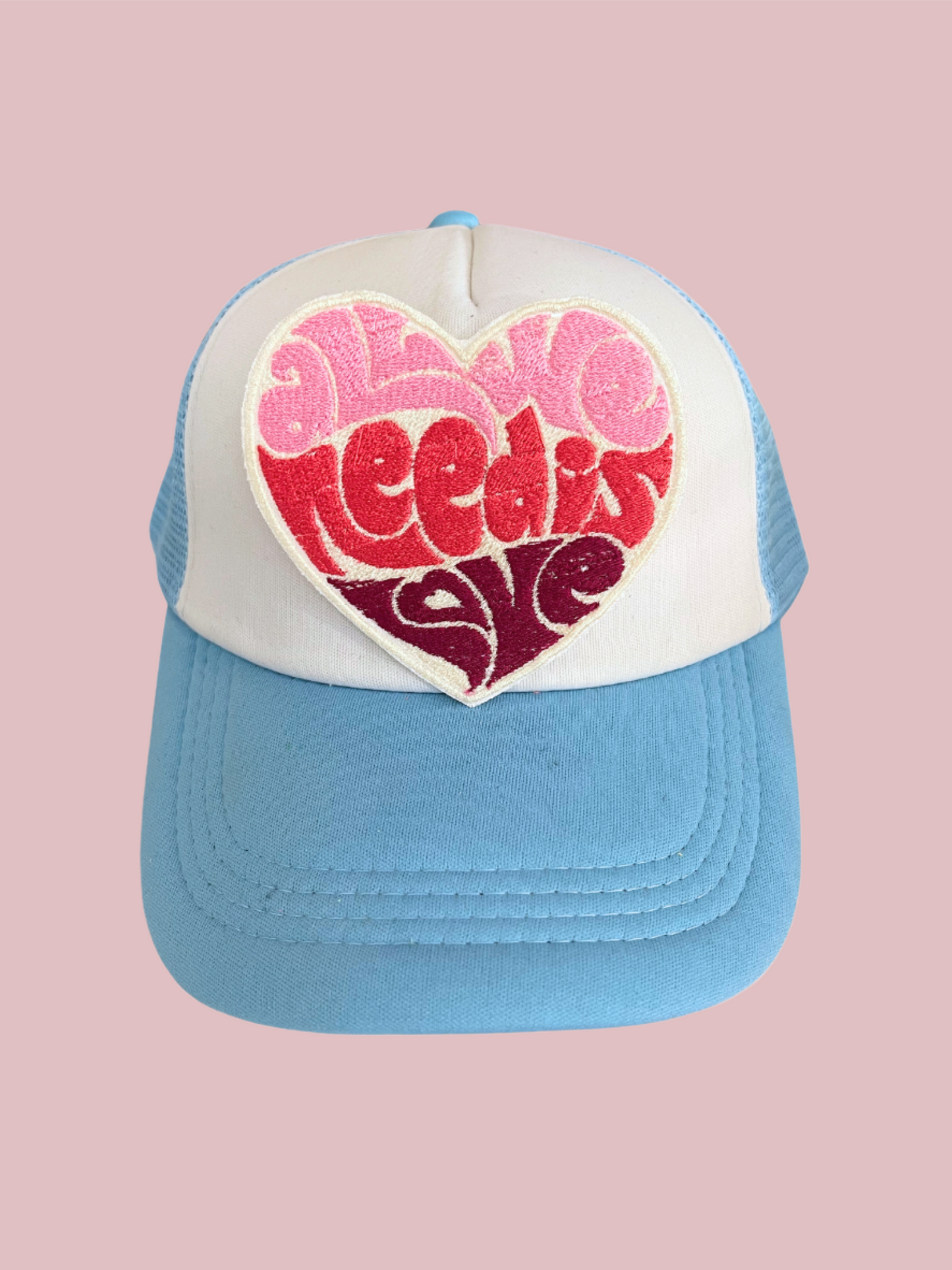 Custom embroidered patch with the text "All We Need is Love" in a heart shape, designed for personalization on hats and apparel.