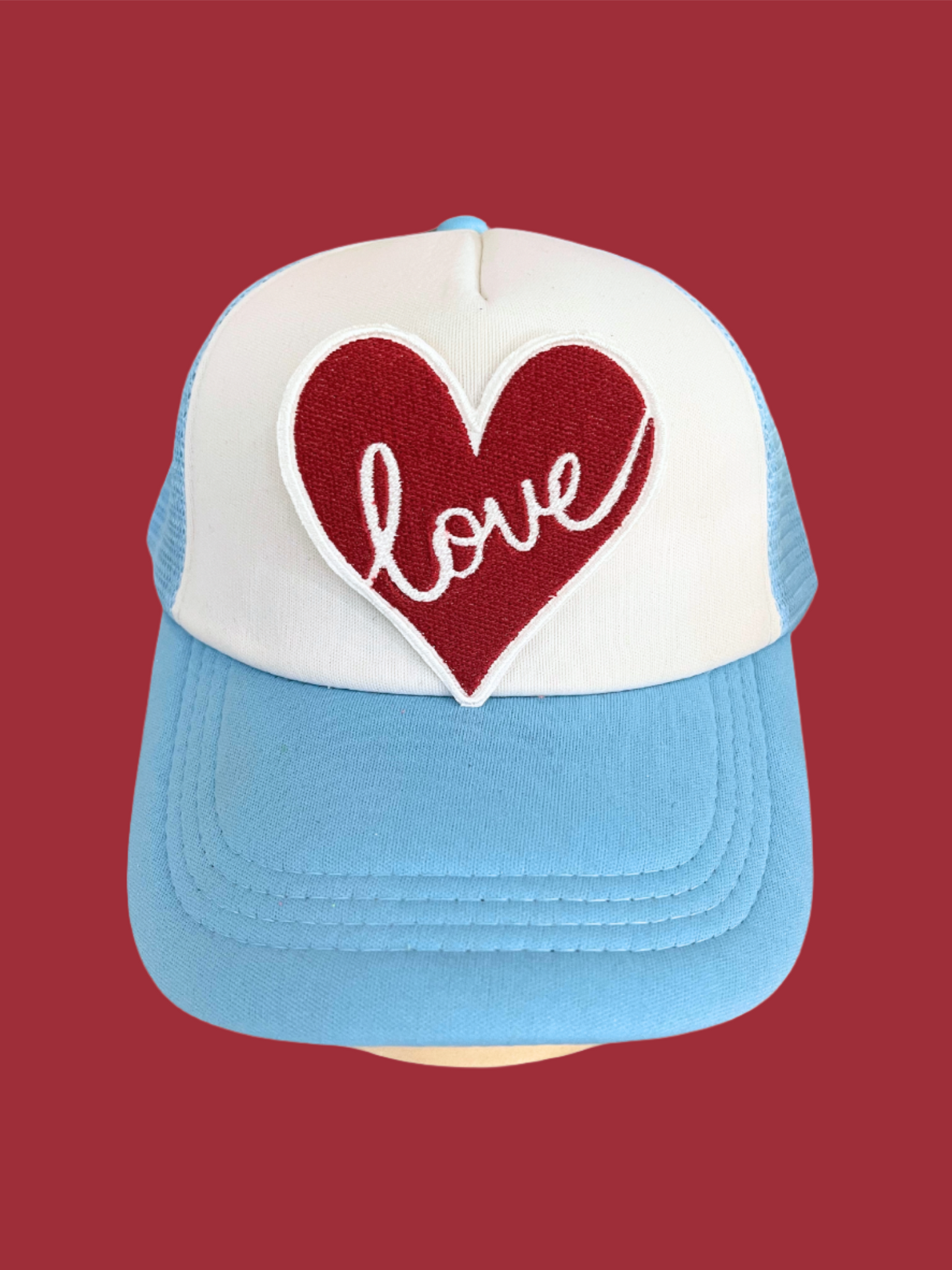 Custom embroidered patch featuring a red heart with the word "love," perfect for personalizing hats and apparel.