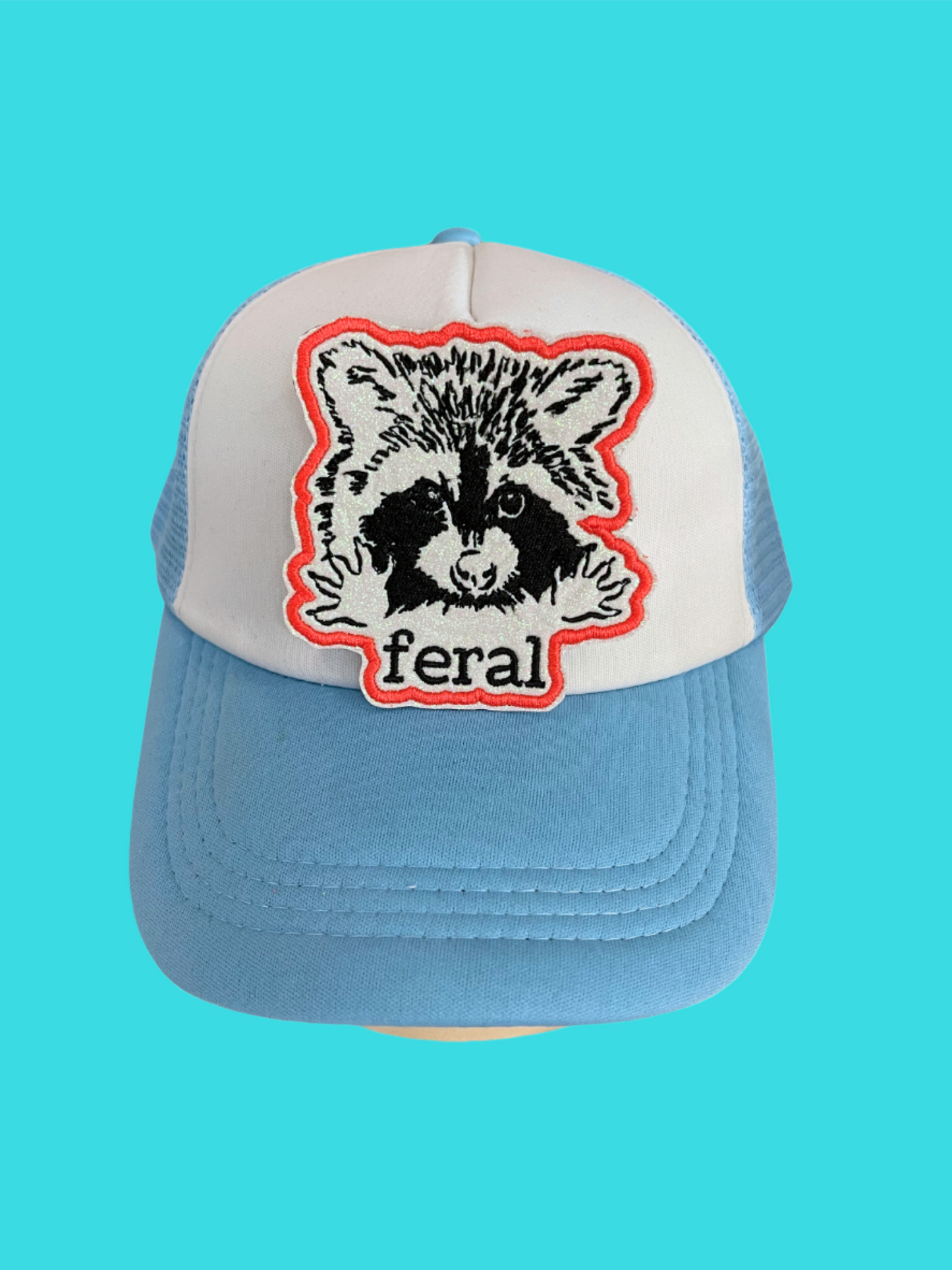 Custom embroidered patch featuring a raccoon with the word "feral," perfect for personalizing hats and apparel.