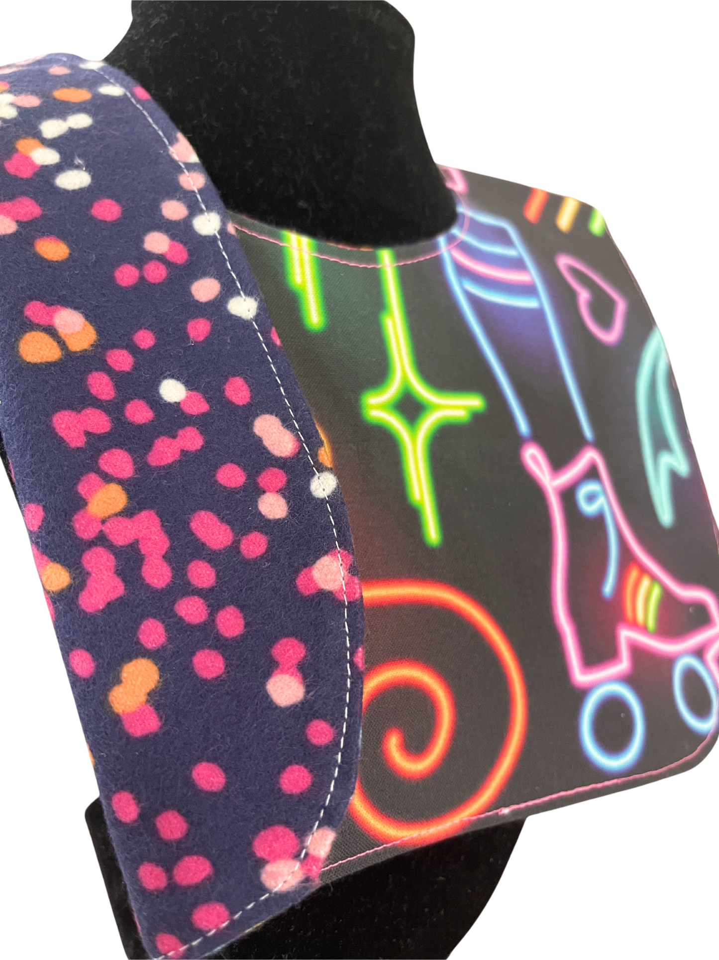 Reversible bib with neon roller skate design and polka-dotted reverse.