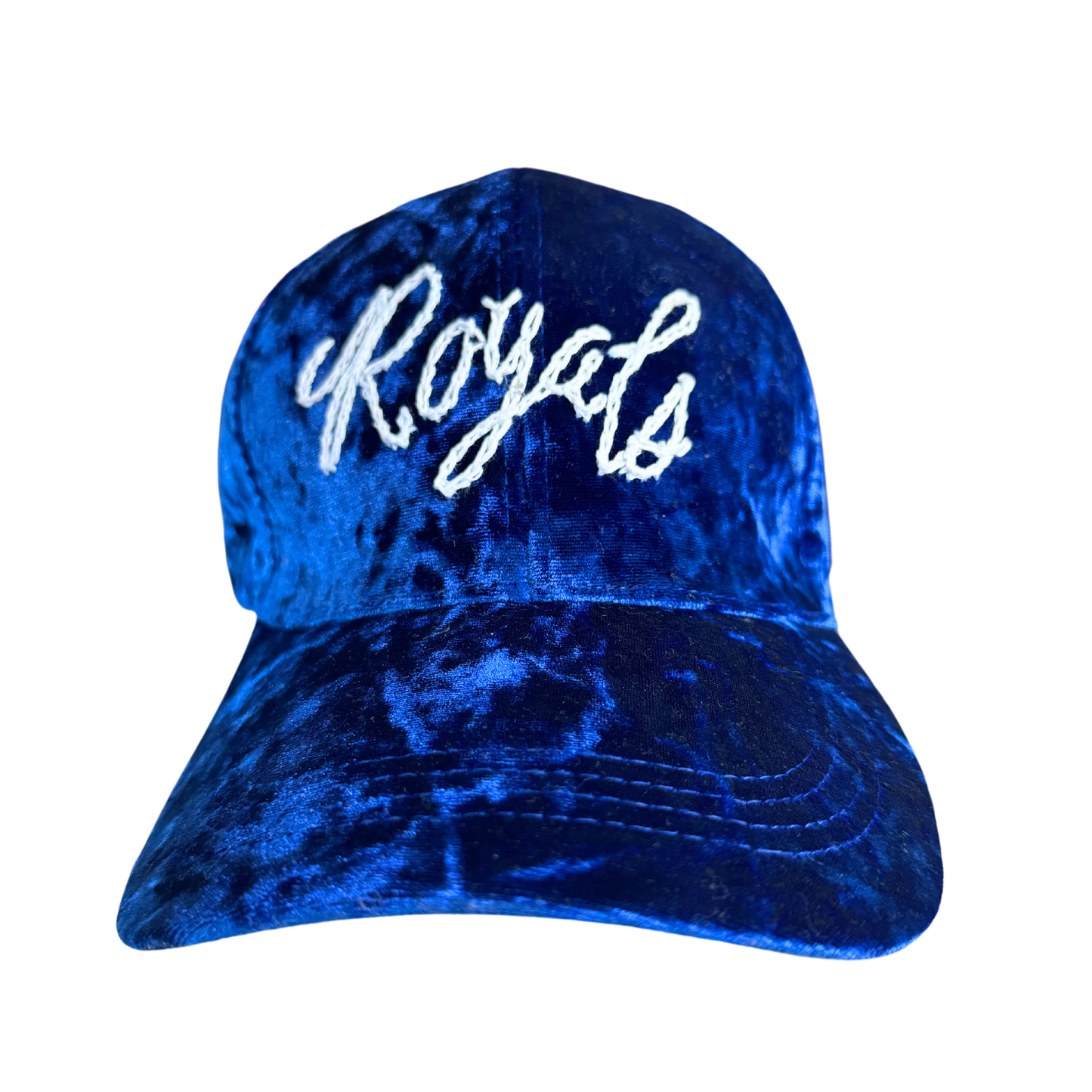 Hand-embroidered "Royals" text on a crushed velvet blue hat.

