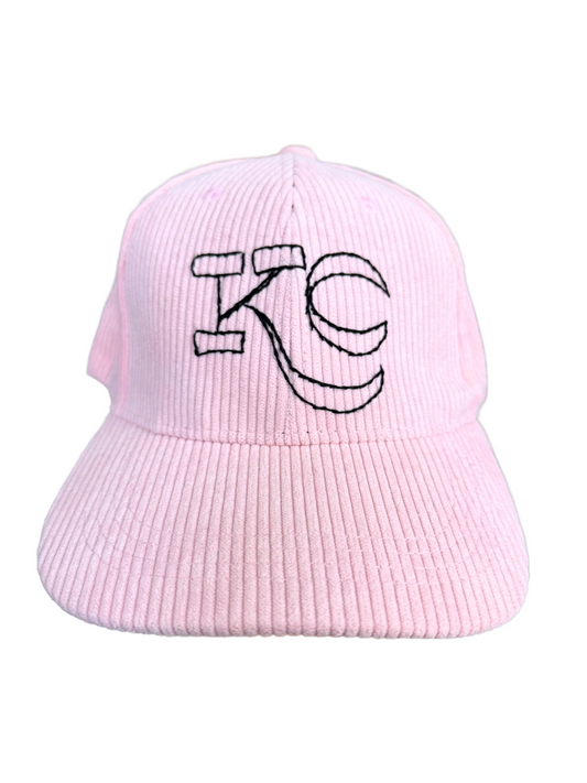 Pink corduroy hat with hand-embroidered black KC logo on front.