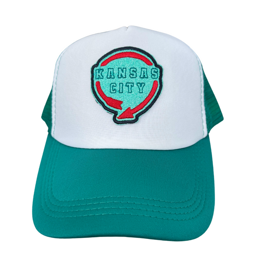 Front view of a trucker hat featuring an embroidered Western Auto logo in KC Current team colors of red and teal, on a white and green hat.

