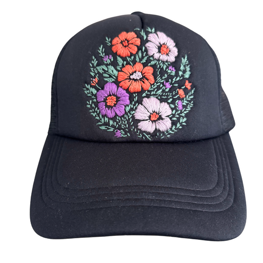 Hand-embroidered floral bouquet design on black hat.

