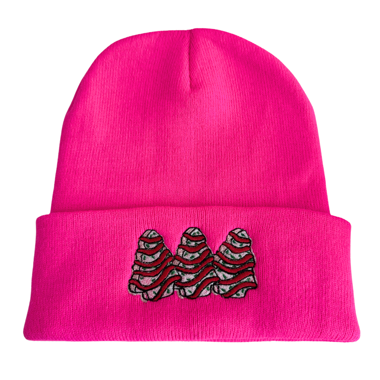 Bright pink beanie with embroidered Christmas tree snack cake design

