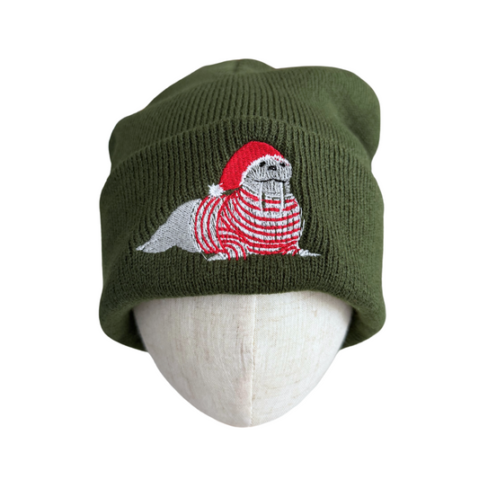 Olive green beanie with festive embroidered walrus in a Santa hat and red striped sweater.

