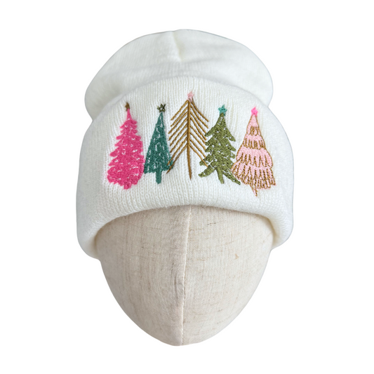 Winter white beanie with embroidered whimsical Christmas trees in various colors and designs
