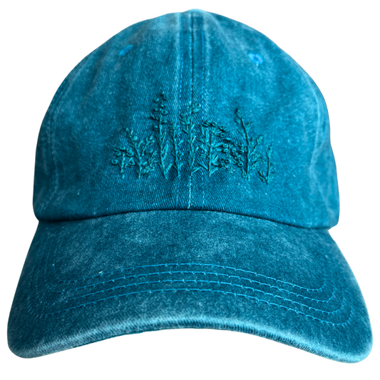 Hand-embroidered wildflower design in teal thread on a teal hat.

