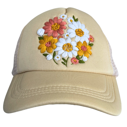 Hand-embroidered floral bouquet design on cream hat.

