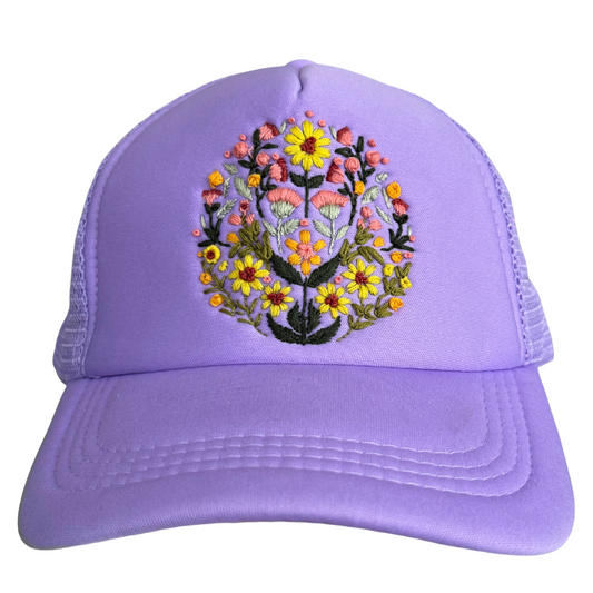 Hand-embroidered blooming garden floral design on a lavender hat.

