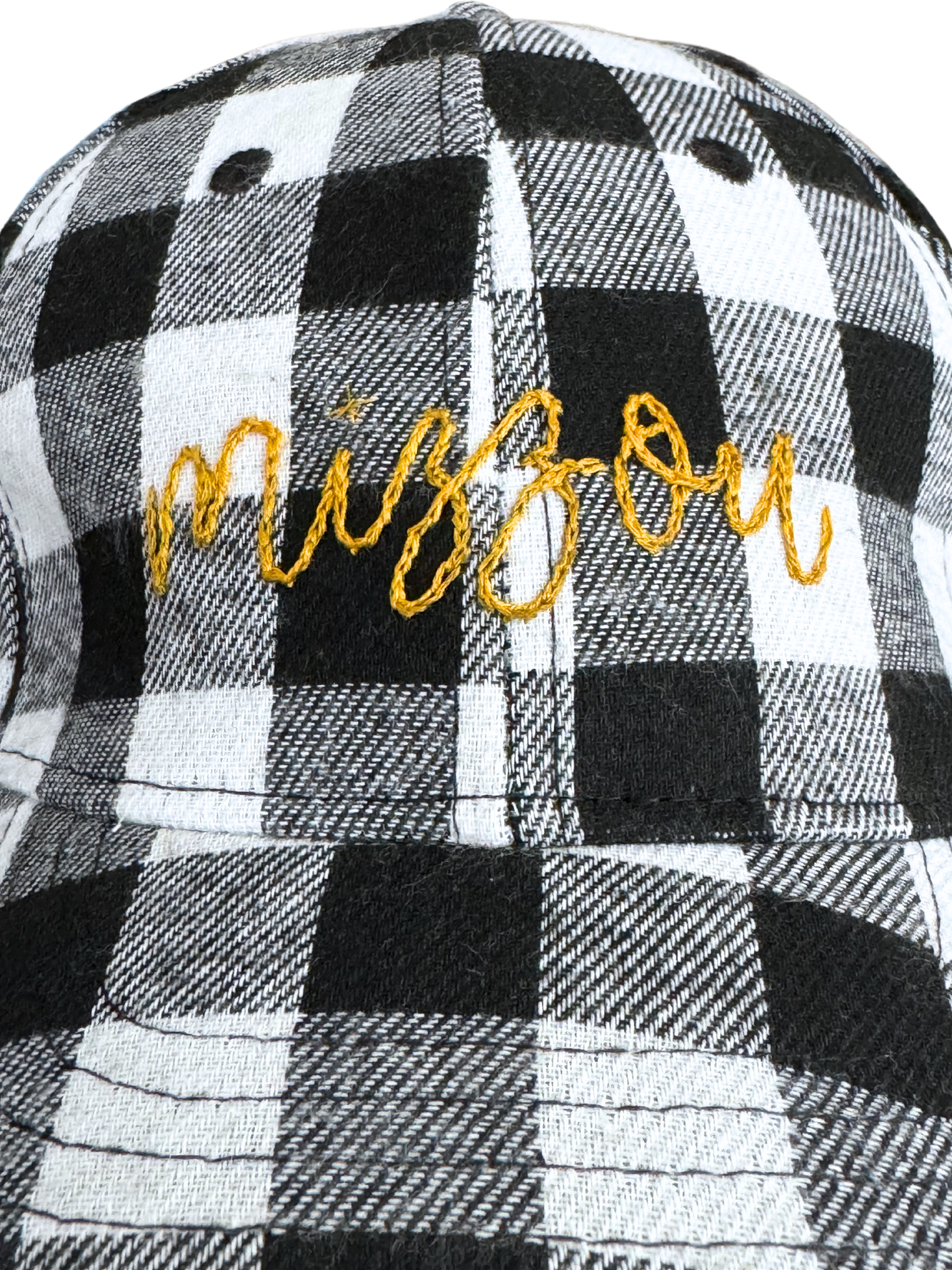 Hand-embroidered "Mizzou" design on black and white plaid hat.

