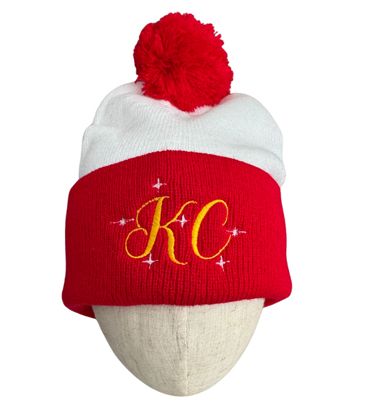 Red and white beanie with a red pom-pom on top and gold "KC" embroidered with sparkle accents, adult size.

