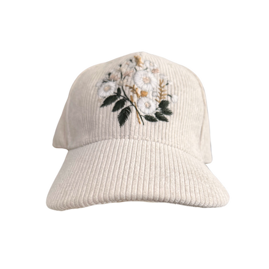 Hand-embroidered white floral design on ivory corduroy hat.

