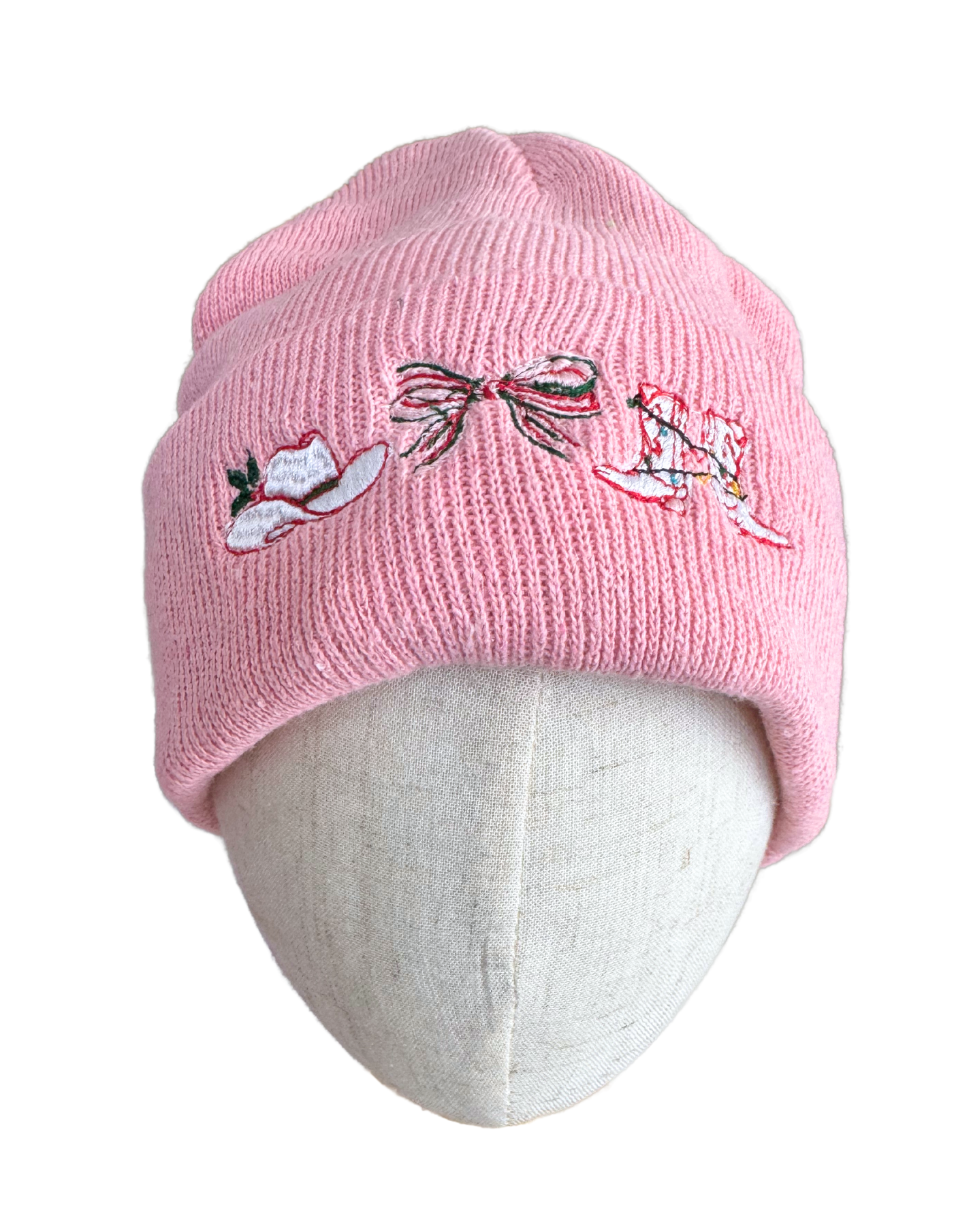 Pink cowboy Christmas beanie with embroidered hat, bow, and boot.