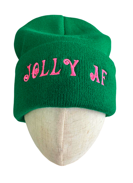 Green beanie with pink "Jolly AF" embroidery in swirled lettering, displayed on a mannequin head.

