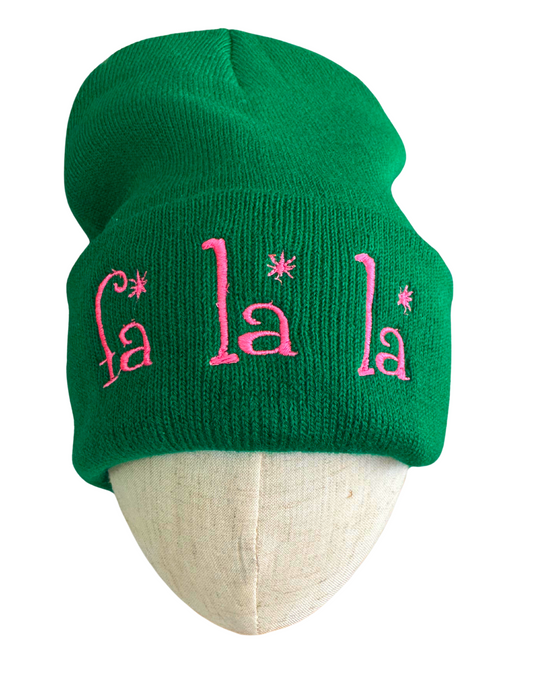 Green beanie with pink embroidered "Fa La La" design featuring whimsical fonts and festive charm.

